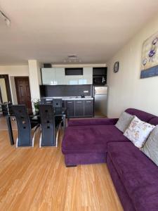 a living room with a purple couch and a kitchen at Sea view apartment in Sveti Vlas in Elenite