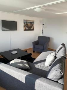 sala de estar con sofá y silla en Apartment Romanshorn von Swisspartments, en Romanshorn