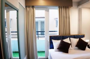 a bedroom with a bed and a window with a view at Dream Hotel - Richmond in Bangalore