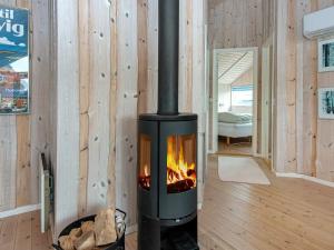 a fireplace in a room with wooden walls at 7 person holiday home in Harbo re in Harboør