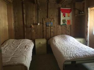 a bedroom with two beds in a wooden wall at Ferienwohnung in Vicosoprano in Vicosoprano