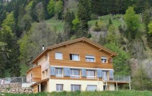 une grande maison au sommet d'une colline dans l'établissement Rigi-Naturferien auf dem Bio-Bauernhof Oberebnet, à Vitznau