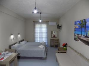 a bedroom with two beds and a table and a window at Afrodite Spacious Apartments! in Agia Effimia