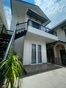 une maison blanche avec un escalier en face de celle-ci dans l'établissement ViVu House2, à Da Thien