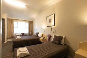 Habitación de hotel con 2 camas y ventana en Mittagong Motel, en Mittagong