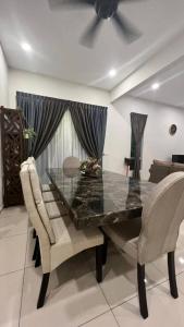 a dining room with a glass table and chairs at Camelia Homestay in Melaka