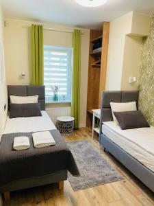 1 dormitorio con 2 camas y ventana en OSTOJA LUSOWO, en Lusowo