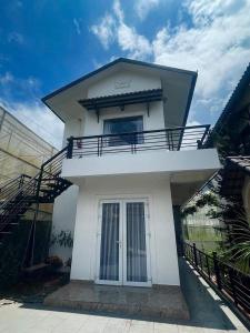 Cette maison blanche dispose d'un balcon. dans l'établissement ViVu House2, à Da Thien