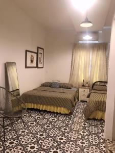 een slaapkamer met 2 bedden en een stoel. bij Lily hostel in Ho Chi Minh-stad
