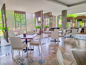 a restaurant with tables and chairs and windows at Sekuro Village Beach Resort in Jepara