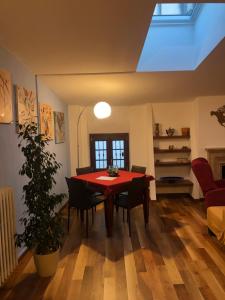 a dining room with a red table and chairs at Frane House in Lazise