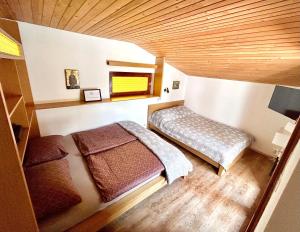 una camera con 2 letti e un soffitto in legno di Family lake house Zbilje a Lubiana