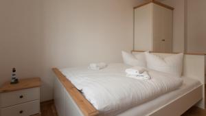 a white bed with two towels on top of it at Stella in der Villa Amelie am Meer in Sassnitz