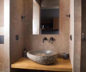 a bathroom with a large stone sink on a wooden counter at Apertura Minima Living space next to sea in Kalamata +34 photos