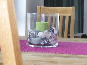a glass vase filled with rocks and a candle on a table at Stella in der Villa Amelie am Meer in Sassnitz