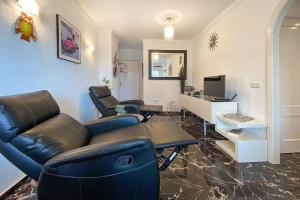 een woonkamer met een bank en stoelen en een bureau bij Stella Maris in Fuengirola