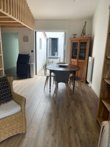 un comedor con mesa y sillas en una habitación en La Caravelle, en Saint Gilles Croix de vie