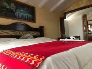 ein Schlafzimmer mit einem Bett mit einer roten Decke darauf in der Unterkunft Hotel Boutique Casa José in Cobán