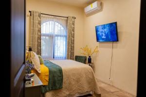 a bedroom with a bed and a window at The Palm- A Luxury Villa in Retalhuleu