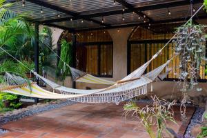 un patio con 2 hamacas colgando de un edificio en The Palm- A Luxury Villa, en Retalhuleu