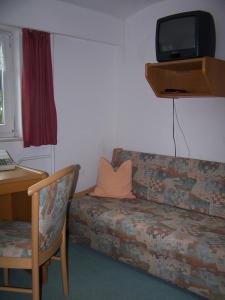 a living room with a couch and a tv on the wall at Hotel Zum Alten Brauhaus in Kurort Oberwiesenthal