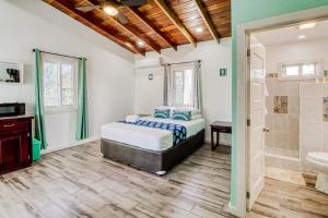 a bedroom with a bed and a bathroom at DV 3 at DV Cabanas Gold Standard Certified in Caye Caulker