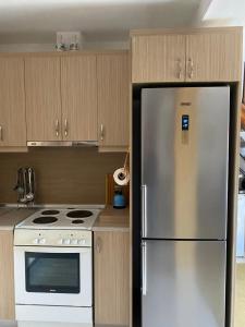 een keuken met een roestvrijstalen koelkast en een fornuis bij Дом для дружной семьи in Mikros Gialos