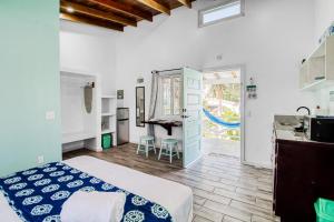 a bedroom with a bed and a kitchen and a table at DV 3 at DV Cabanas Gold Standard Certified in Caye Caulker