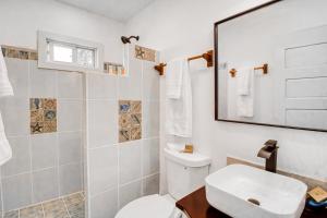 a white bathroom with a toilet and a sink at DV 3 at DV Cabanas Gold Standard Certified in Caye Caulker