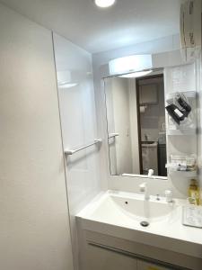 a bathroom with a sink and a mirror at Ao Hotel in Nago