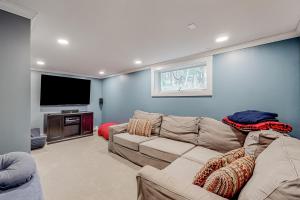 a living room with a couch and a flat screen tv at Mad River Valley Ski Chalet in Waitsfield