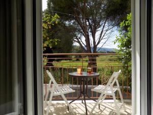 a table and two chairs on a balcony with a candle at Afrodite Spacious Apartments! in Agia Effimia