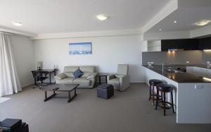 a kitchen and a living room with a couch and a table at Curtis Central Apartments Official in Gladstone