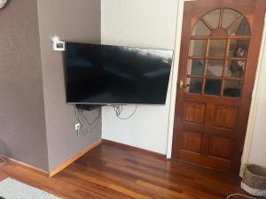 TV de pantalla plana colgada en una pared junto a una puerta en Casa di Lauza en Valkenburg