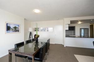 a kitchen and dining room with a table and chairs at Curtis Central Apartments Official in Gladstone
