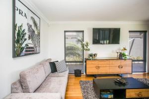a living room with a couch and a tv at 2 Luxury Canal Holiday Homes - Sleep 28 in Mandurah