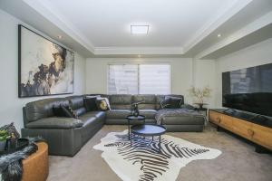 a living room with a couch and a flat screen tv at 2 Luxury Canal Holiday Homes - Sleep 28 in Mandurah +62 photos
