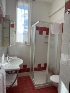 a bathroom with a shower and a sink and a toilet at Hotel Reno in Lido di Jesolo