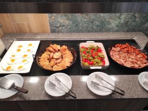 a kitchen with three pans of food on a counter at Santa Maria City Hotel in Rhodes Town