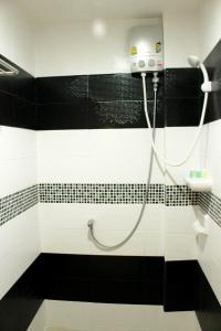 a bathroom with a shower with black and white tiles at Donmueang Airport Modern bangkok in Ban Ko