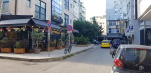 eine Straße mit einem Auto auf der Straßenseite in der Unterkunft Nevila's apartment in Tirana