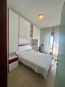 1 dormitorio con 1 cama y armarios blancos en Hotel Reno, en Lido di Jesolo