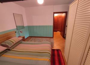 una camera con un grande letto e un corridoio di CASA PERMIRRA a Feltre