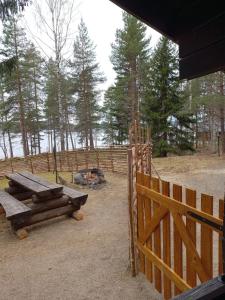 a wooden fence with a picnic table next to a gate at Accommodation and Fishing Vonkale in Äänekoski +47 photos