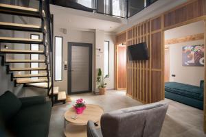 a living room with a staircase and a couch and a table at Apertura Minima Living space next to sea in Kalamata