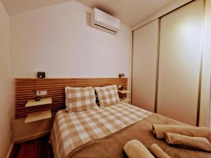 a small bedroom with a bed with a checkered blanket at Mouraria Studios & Flats by Lisbon Village Apartments in Lisbon