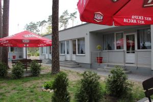 budynek z czerwonym parasolem, stołami i ławkami w obiekcie Oaza w Turawie