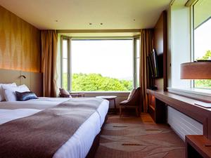 a hotel room with a bed and a large window at Hakodate-Onuma Prince Hotel in Nanae