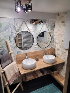 ein Badezimmer mit zwei Waschbecken und zwei Spiegeln in der Unterkunft Chaleureuse bergerie rénovée. in Tourrette-Levens