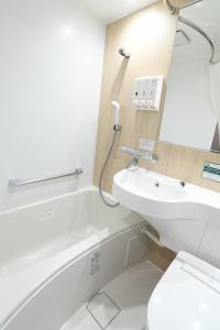 y baño con aseo blanco y lavamanos. en R&B Hotel Ueno Hirokoji, en Tokio